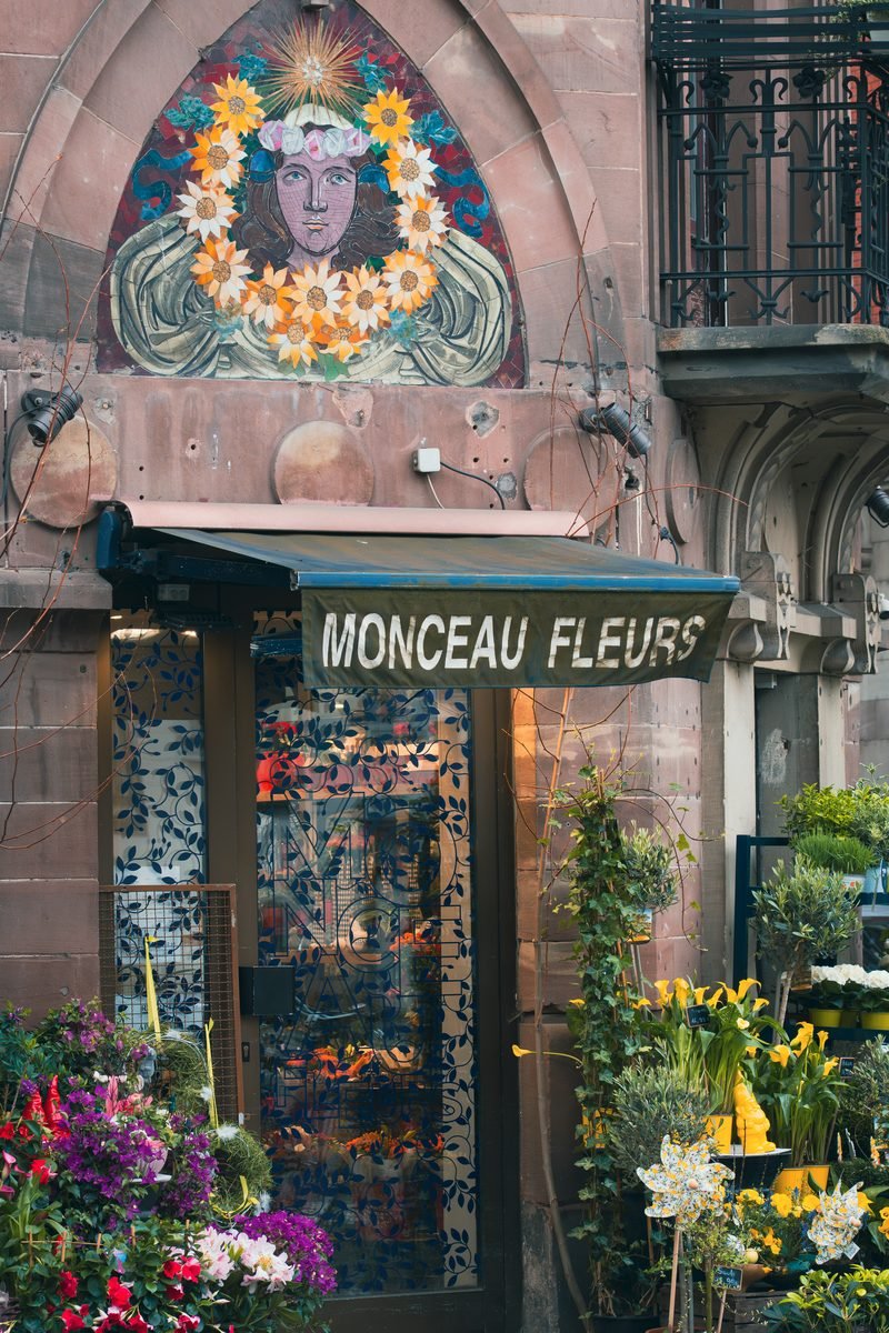 Geschmücktes Schaufenster eines Blumenladens mit Auslage auf dem Gehweg