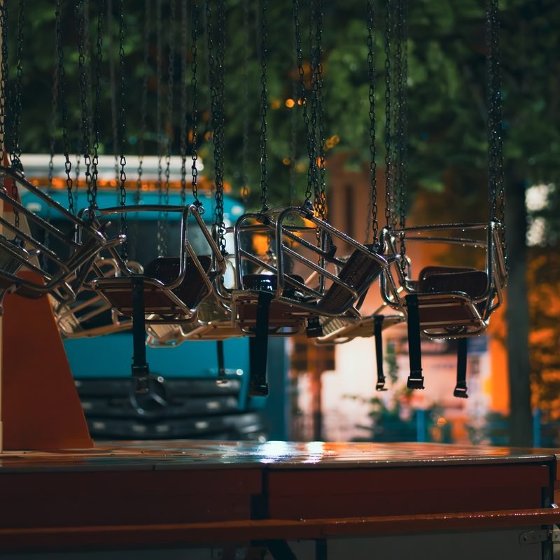 Lichter und Sitze eines Kettenkarussells auf der Kirmes am Abend