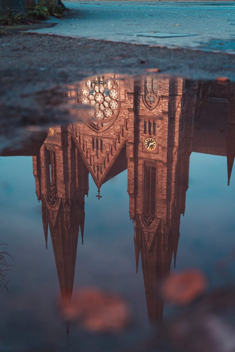 Kathedrale spiegelt sich kopfüber in einer Pfütze auf dem Pflaster